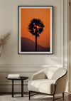 Een prachtig ingelijste foto van een palmboom bij zonsondergang siert de muur boven een moderne witte fauteuil en zwarte bijzettafel in een minimalistische woonkamer. Dit prachtige Shining through schilderij van CollageDepot zorgt met zijn oranje lucht en bergsilhouet voor een warme sfeer. Hoog gras siert de hoek van de kamer.
