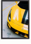 Een close-upbeeld van het voorste gedeelte van een gele Ferrari 488 Pista met zwarte en zilveren racestrepen. De auto staat geparkeerd op een betonnen ondergrond in een garage en dient als opvallend wanddecor. De foto van de Prachtige gele Ferrari 488 Pista van CollageDepot is omlijst met een zwarte rand, versterkt door een magnetisch ophangsysteem.,Zwart-Zonder,Lichtbruin-Zonder,showOne,Zonder