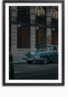 Een ingelijste foto toont een vintage blauwe Mercedes-Benz geparkeerd voor een Hermes-winkel. Het sierlijke gebouw is voorzien van ingewikkeld smeedwerk en grote ramen, die een avondsfeer met weinig licht weerspiegelen. De straat is leeg, wat bijdraagt aan de serene sfeer: een perfecte Blauwe Vintage Mercedes Schilderij van CollageDepot voor elke ruimte.,Zwart-Met,Lichtbruin-Met,showOne,Met