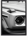 Een close-up van de voorste hoek van een Mercedes G Wagon AMG, met een ronde koplamp en een klein koepelvormig lampje erboven. De afbeelding is ingelijst in een zwarte lijst met witte rand, ideaal voor wanddecoratie. Het strakke en moderne ontwerp van het voertuig komt schitterend naar voren in het Mercedes G Wagon Voorkant Schilderij van CollageDepot.,Zwart-Zonder,Lichtbruin-Zonder,showOne,Zonder