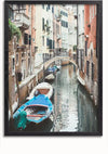 Een smal kanaal in Venetië, Italië, geflankeerd door oude gebouwen. Langs één kant liggen drie kleine boten aangemeerd, en op de achtergrond overspant een gebogen loopbrug het kanaal. De scène is rustig met reflecties in het water, zoals een schilderij van Kanaal in Venetië van CollageDepot, perfect voor je wanddecoratie.