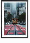 Een kabelbaan uit San Francisco rijdt door een steile straat in de stad, omgeven door hoge gebouwen en bomen. De straat is gemarkeerd met rode rijstroken en aan weerszijden zijn andere auto's te zien. De scène is ingelijst in wat lijkt op een zwarte fotolijst, waardoor het een perfecte wanddecoratie voor je huis is. Dit is het Tram In San Francisco-schilderij van CollageDepot.,Zwart-Met,Lichtbruin-Met,showOne,Met