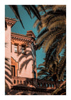 Een gebouw in mediterrane stijl met sierlijke ramen en een terracotta dak dat door weelderige groene palmbladeren naar voren steekt tegen een helderblauwe lucht. Het warme zonlicht werpt een rustige sfeer over het CollageDepot bbb 015 - natuur.-