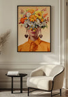 Op een muur hangt een Orange Flower Lady Schilderij van CollageDepot, met een afbeelding van een persoon in een oranje outfit met een hoed gemaakt van bloemen, waardoor het gezicht wordt verborgen. Onder het kunstwerk staat een beige fauteuil en een klein zwart bijzettafeltje met een boek. Deze charmante wanddecoratie accentueert de witte lambrisering en de gedroogde planten.,Zwart