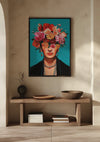Een ingelijst portret met de titel "Extravagant Flower Lady Schilderij" van CollageDepot met florale elementen op haar hoofd hangt als wanddecoratie aan een beige muur boven een houten consoletafel. Op de tafel staan een zwarte vaas, een kom, een bord en gestapelde boeken. De kamer wordt zacht verlicht met zacht, natuurlijk licht.,Zwart