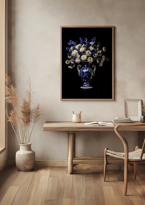 Een minimalistische kamer met een lichthouten bureau en stoel, versierd met een vaas met pampasgras op de vloer. Aan de muur hangt een ingelijste foto van blauwe en witte bloemen in een vaas. Op het bureau staat een stapeltje boeken en nog een vaas, met name de aab 337 Delfts blauw van CollageDepot.,Lichtbruin