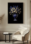 Een ingelijste foto van aab 337 Delfts blauw van CollageDepot hangt aan een muur boven een lichtgekleurde fauteuil en een klein zwart bijzettafeltje. De kamer heeft een licht interieur met witte lambrisering.,Zwart
