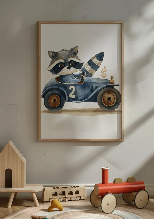 Aan een lichtgekleurde muur hangt een ingelijst Wasbeer In Blauwe Auto Schilderij van CollageDepot. Onder de wanddecoratie bevindt zich houten speelgoed waaronder een klein huisje, een trein en een rode speelgoedauto op een houten vloer. Er is ook een gevulde pompoen zichtbaar.,Lichtbruin