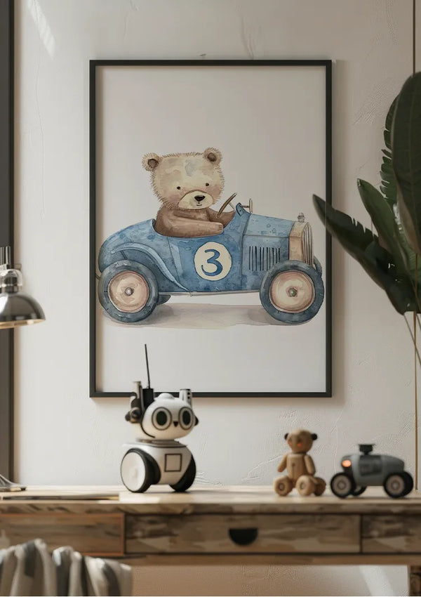 Aan een witte muur hangt een ingelijste Teddybeer In Blauwe Vintage Auto Schilderij van een teddybeer die een blauwe auto bestuurt met het cijfer 3. Deze charmante wanddecoratie van CollageDepot wordt aangevuld met een houten bureau eronder, met een kleine robot, een speelgoedteddybeer en een miniatuurautomodel. Aan de rechterkant van de afbeelding is gedeeltelijk een groene plant zichtbaar.,Zwart