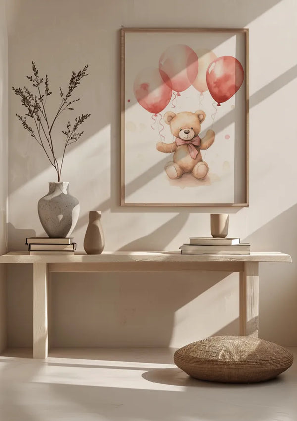 Een minimalistische kamer is voorzien van een ingelijste Teddybeer Met Roze Ballonnetjes Schilderij van CollageDepot van een teddybeer met rode ballonnen aan de muur. Hieronder staat een houten bankje met drie vazen en twee gestapelde boeken. Het zonlicht stroomt van rechts naar binnen en werpt schaduwen op de bank en de vloer.,Lichtbruin